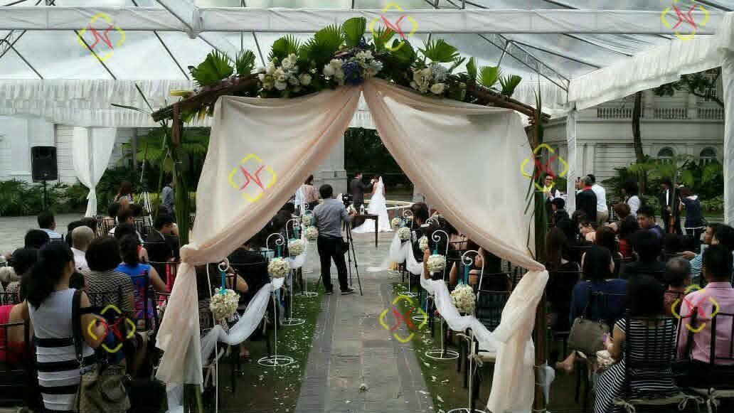 Outdoor wedding ceremony beneath a clear tent with sound coverage along the aisle